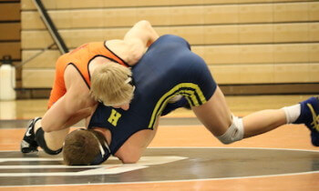 Lee Grabowski, shown wrestling Hartland's Nick Dinobile, took a 7-3 decision for his 100th career victory on Wednesday.